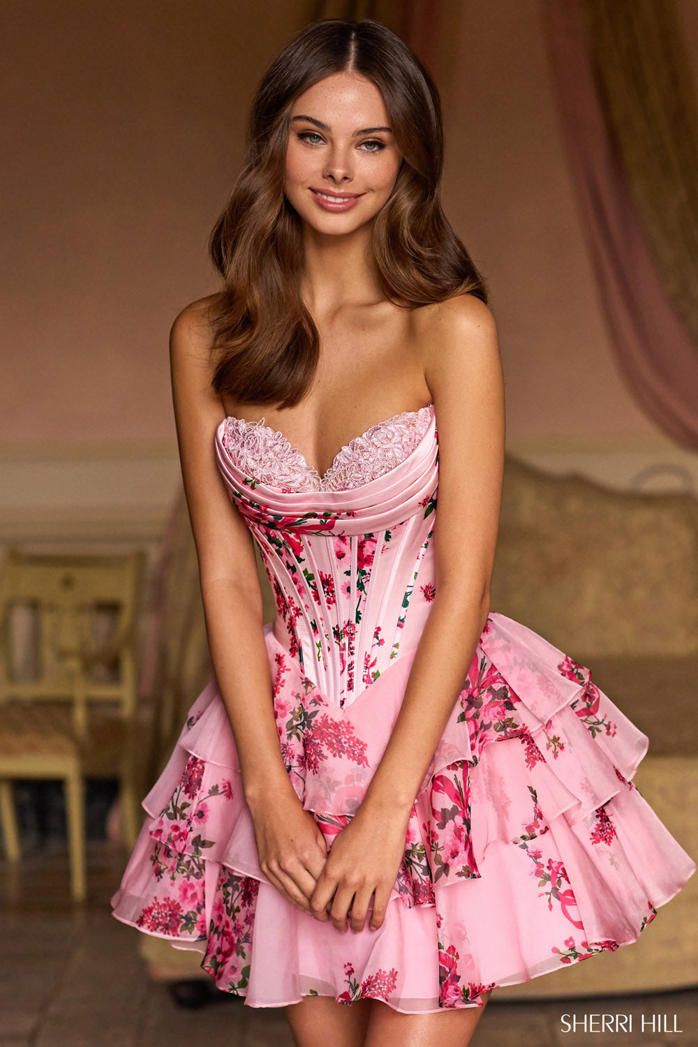 Model wearing Sherri Hill 57296 formal dress in Pink Print floral corset bodice, lace sweetheart neckline, and tiered chiffon ruffle skirt.