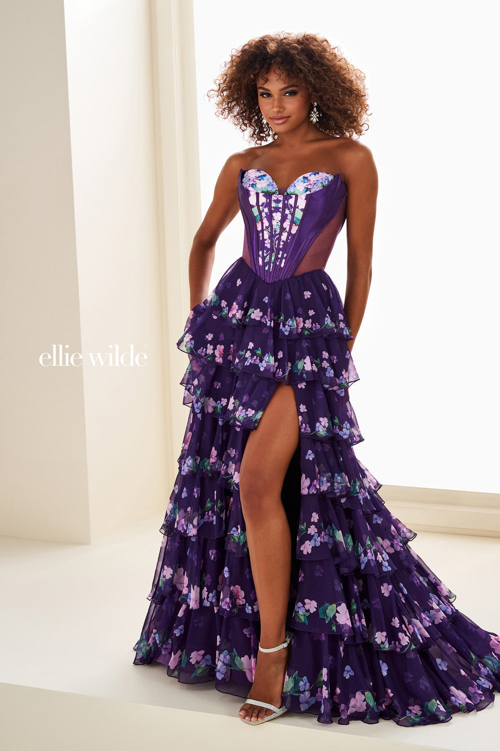 Ellie Wilde EW37001, A-line dark purple prom dress with corset bodice and slit detail.