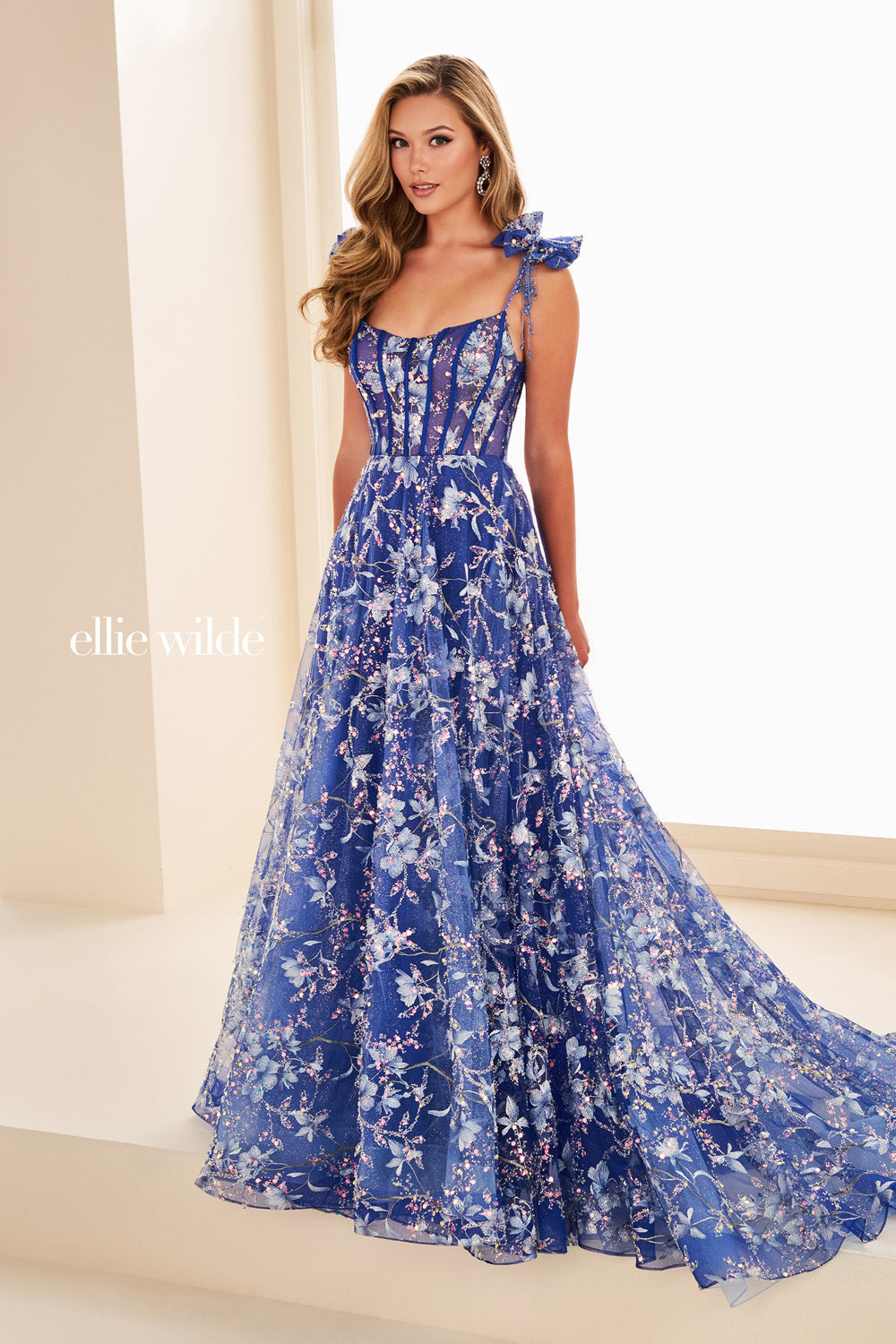Ellie Wilde EW37020 blue floral gown with flowing a line silhouette and ruffled straps prom dress images.