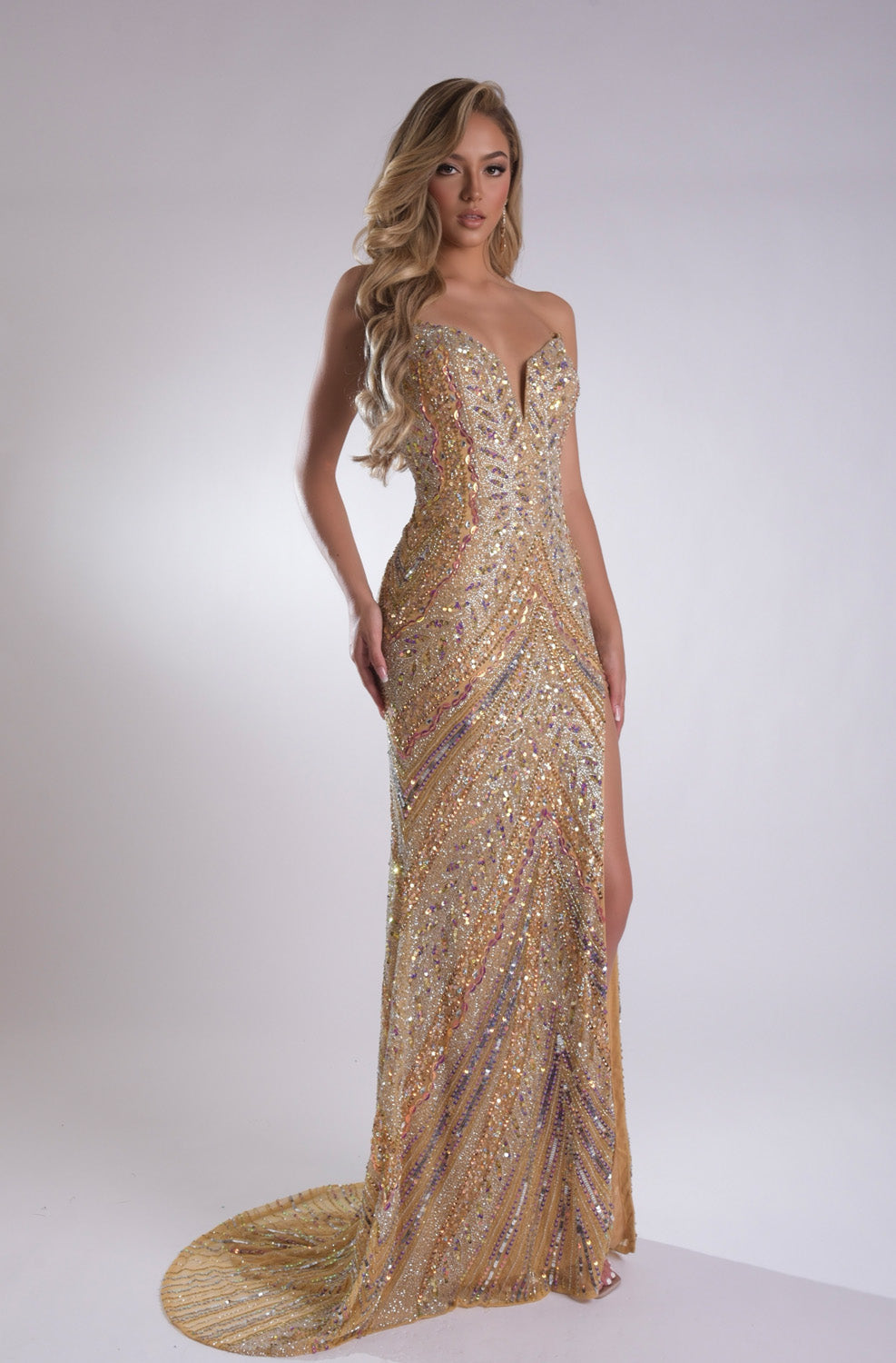 Jasz Couture 7910 Gold mermaid prom dress with sequins and a thigh-high slit, side view.