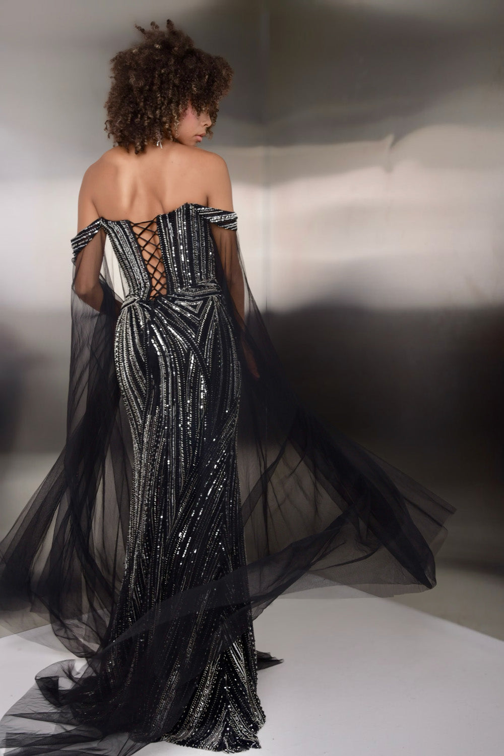 Jasz Couture 7938 Black mermaid prom dress with a lace-up back and shimmering sequins, back view.