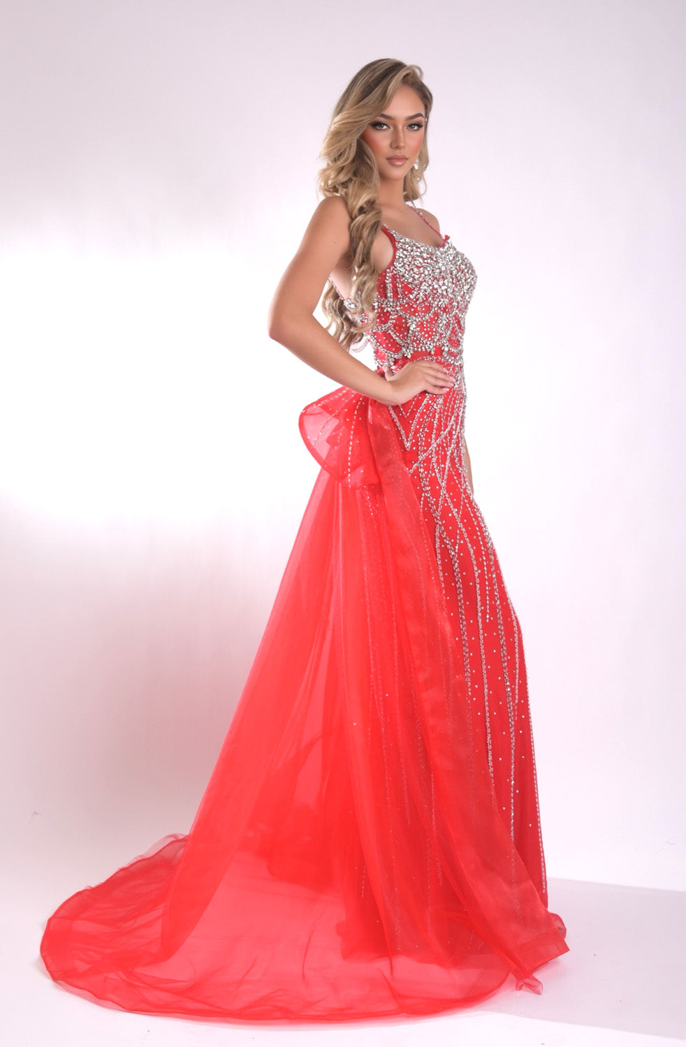 Jasz Couture 7946 Red mermaid prom dress with beading and a dramatic train, side view.