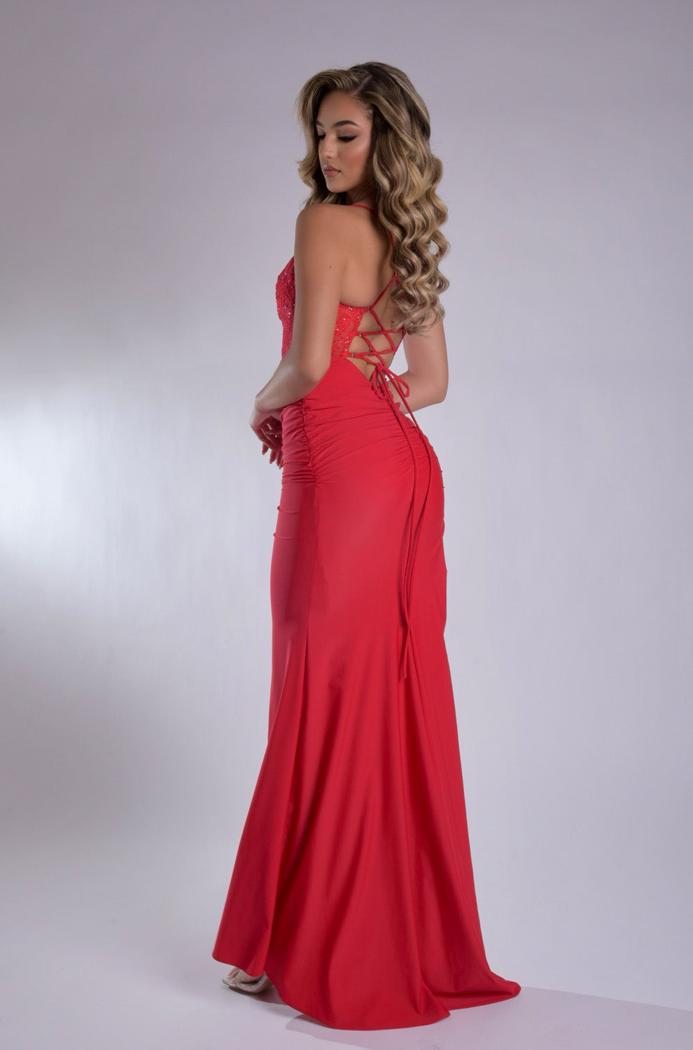 Jasz Couture 7986 Red fitted prom dress with a lace-up back and elegant silhouette, back view.