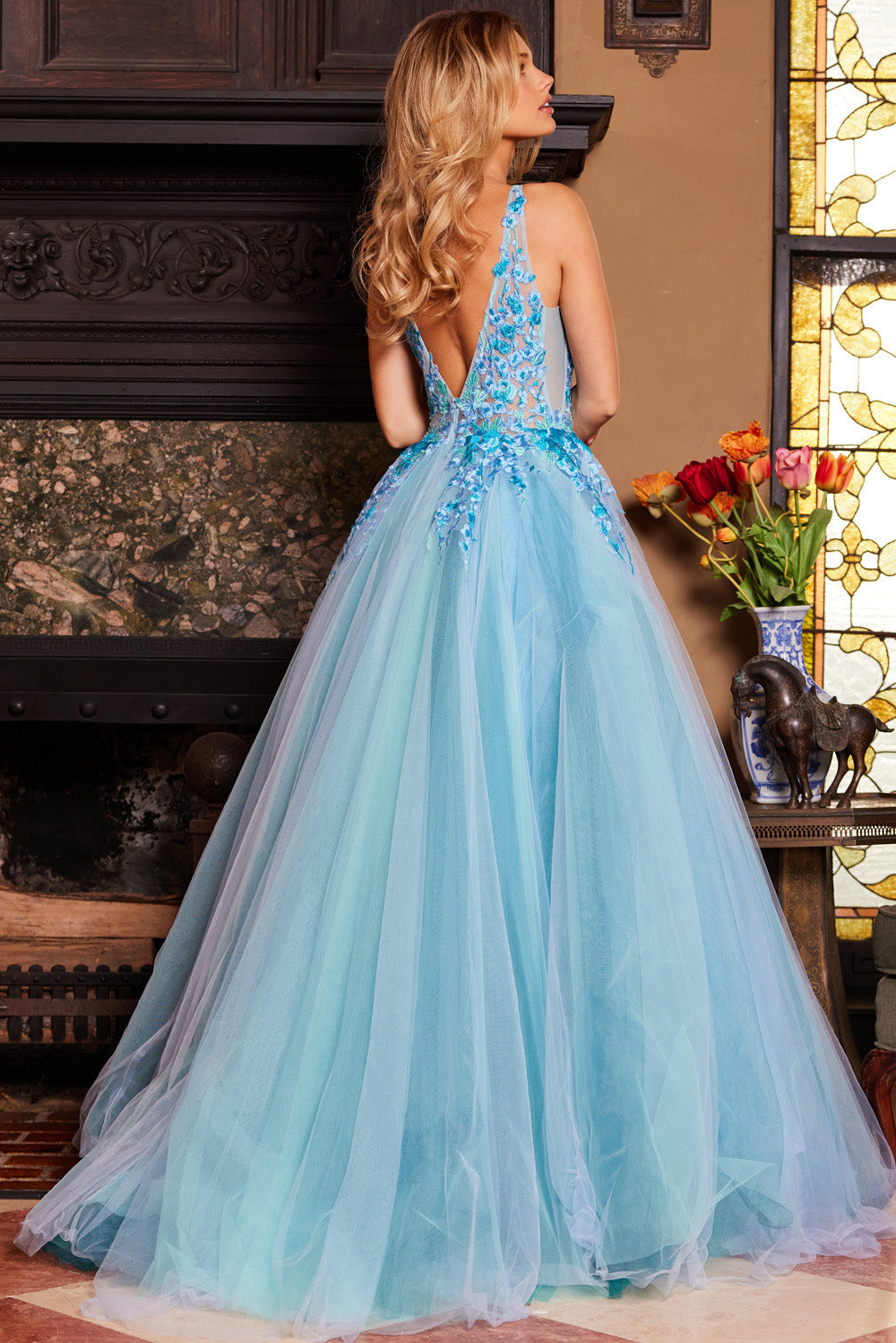 Jovani 23577 Blue multi A-line prom dress with a deep V-back and floral embellishments.