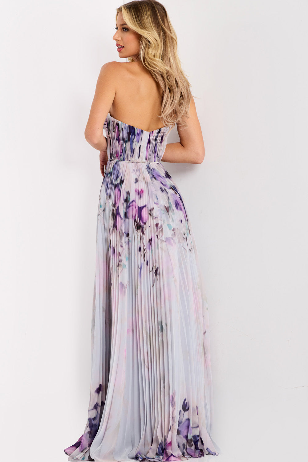 Jovani 42564 Purple floral print formal gown with a fitted bodice and pleated skirt, back view.