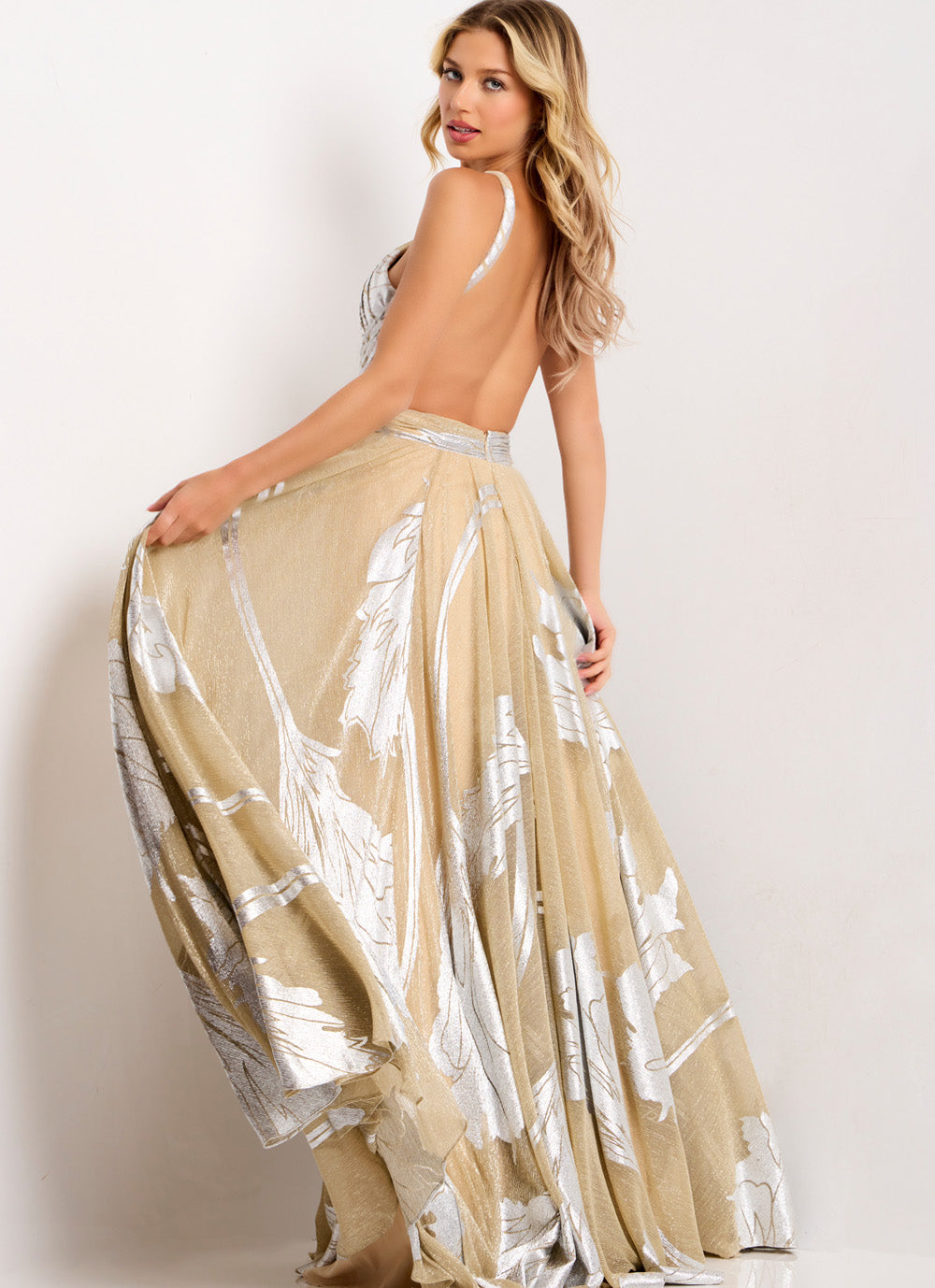 Jovani 44421 Nude silver formal gown with a flowing silhouette and open back design.