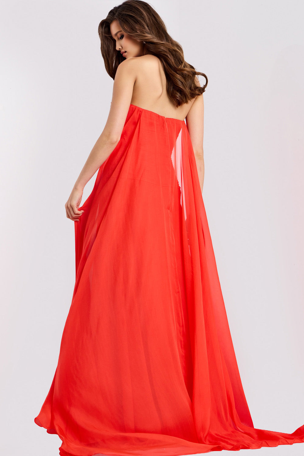 Jovani 45269 Strapless red prom dress with flowing cape and open back design.