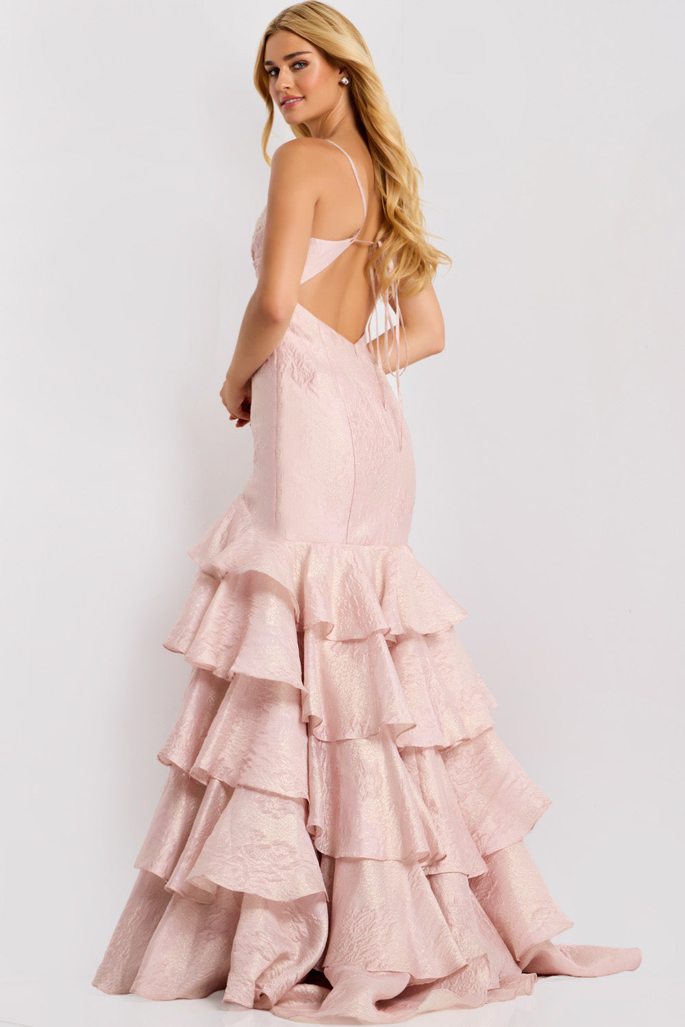 Jovani 47329 Pink mermaid prom dress with ruffled layers and a lace-up back, back view.