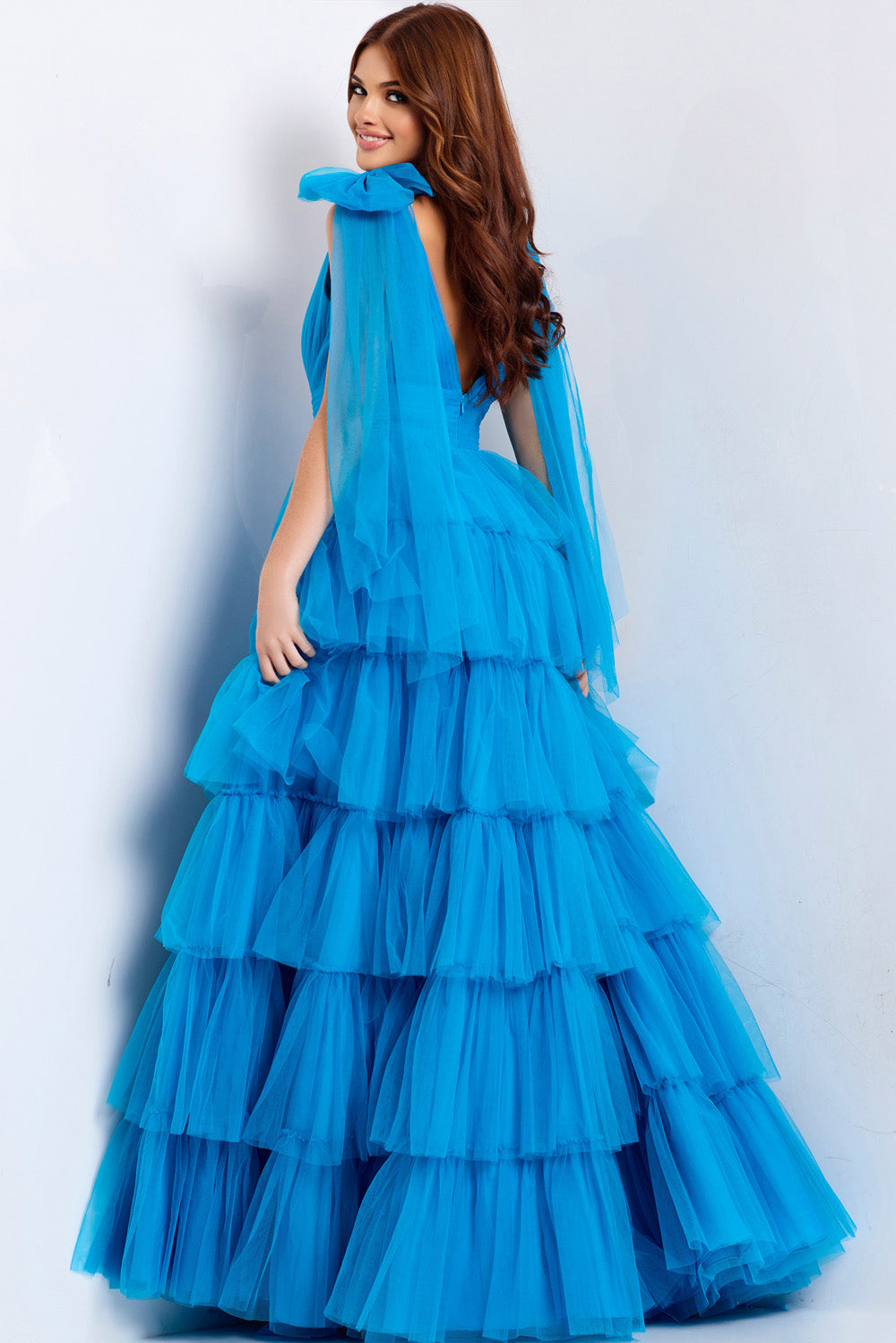 Jovani 48288 Turquoise tiered prom dress with flowing sleeves and a backless design.