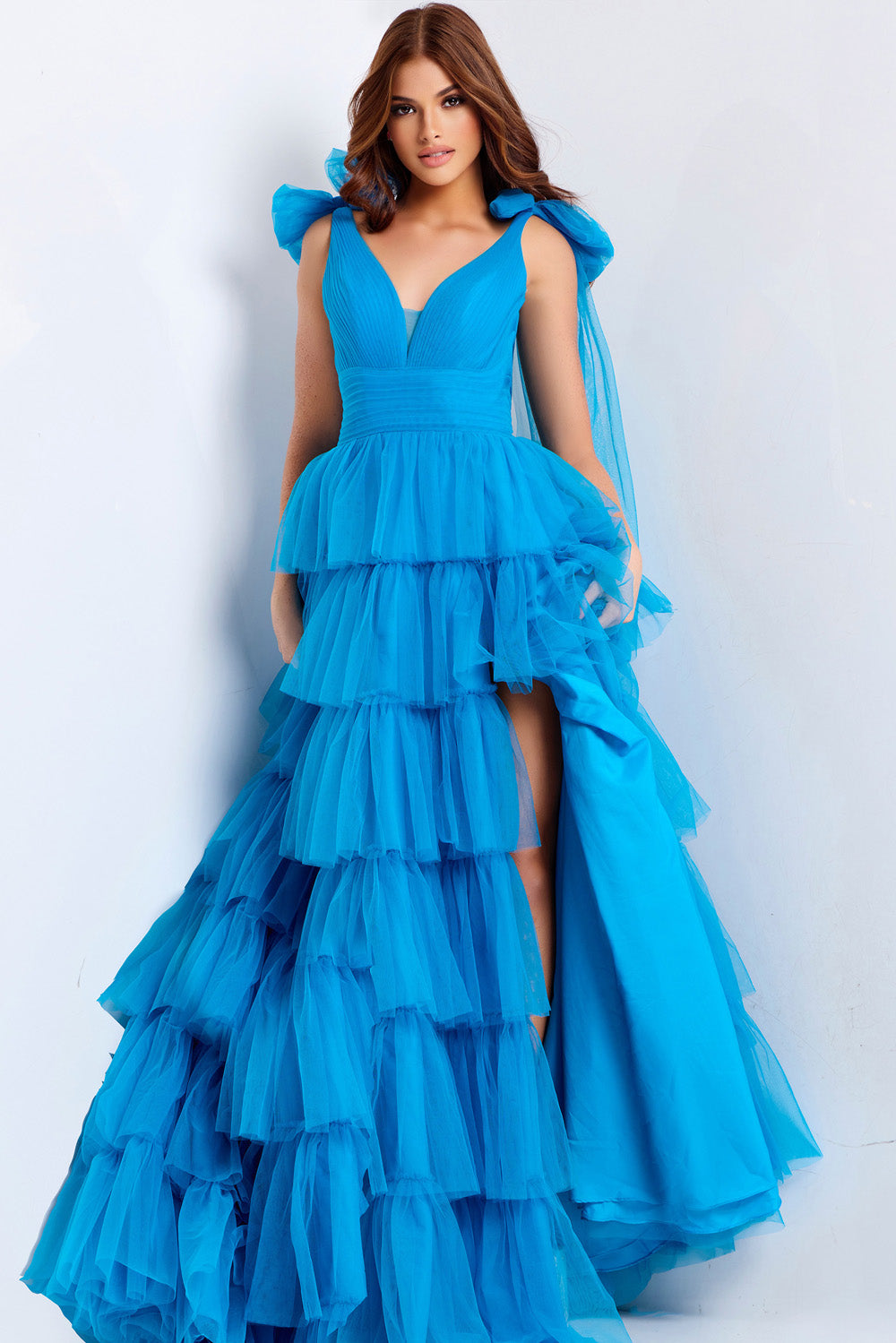Jovani 48288 Turquoise tiered prom dress with a high slit and bow shoulder details.