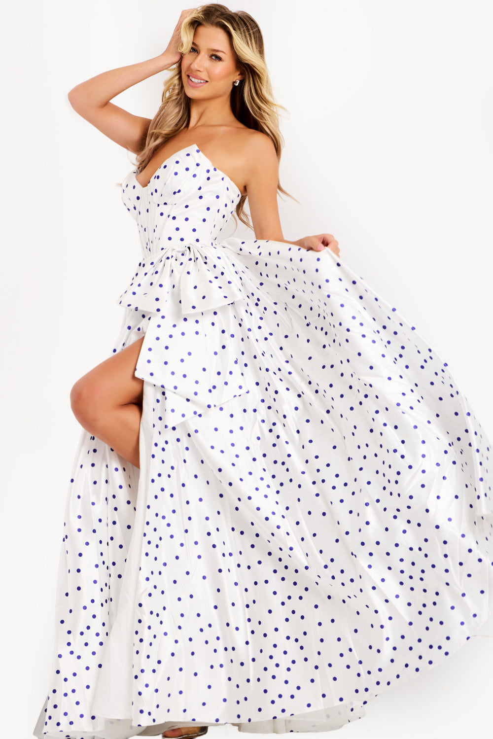 Jovani 49899 White polka dot prom dress with a fitted bodice and high slit, side view.