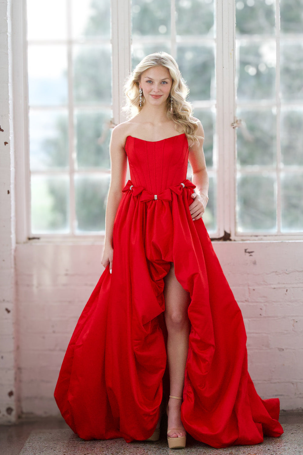 Miah Vega 24601 Red strapless prom dress with high slit and flowing skirt, front view.