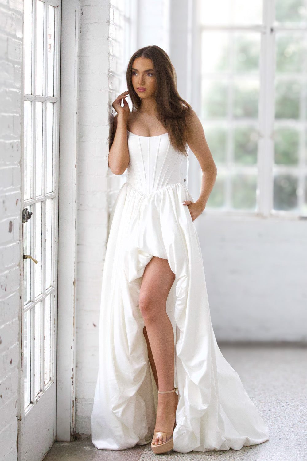 Miah Vega 24601 White prom dress with a high slit and fitted bodice, showcasing a dramatic silhouette.