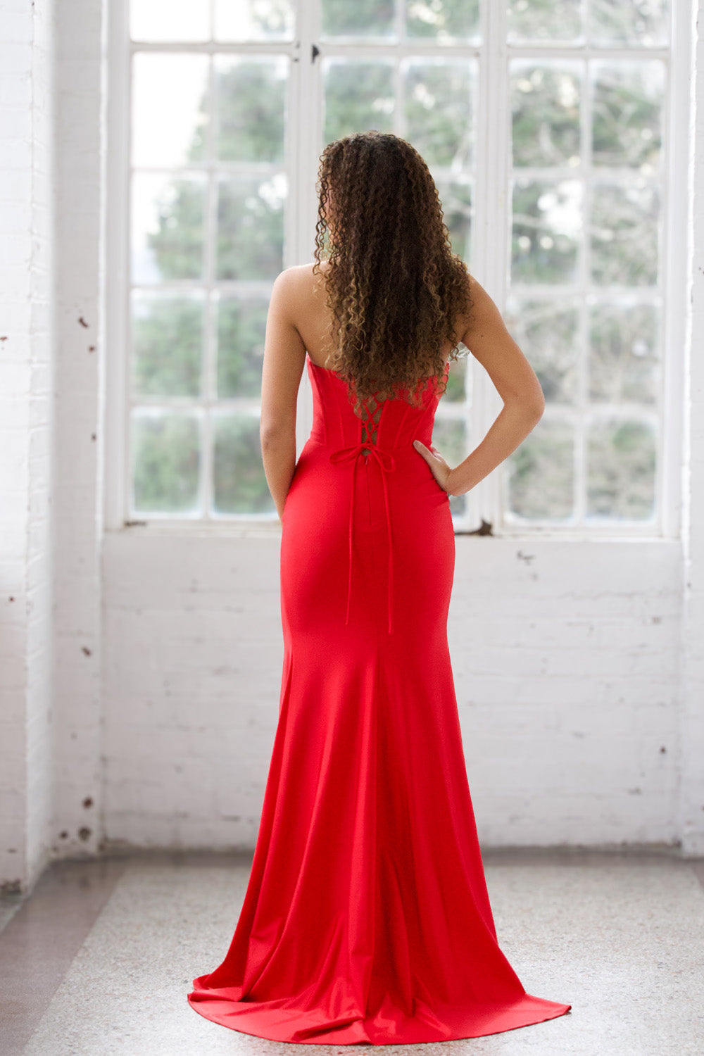Miah Vega 24604 Red mermaid prom dress with a lace-up back, showcasing a sleek silhouette.