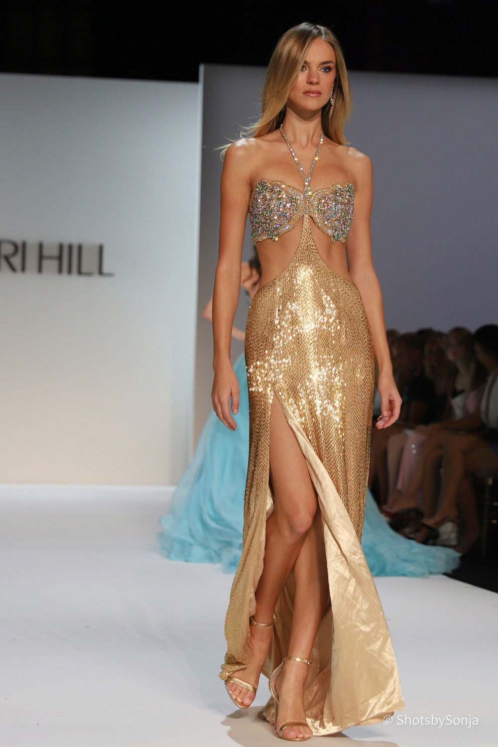 Sherri Hill 46717 gold couture gown full length view showing beaded bodice open waist fitted gold skirt and high front slit