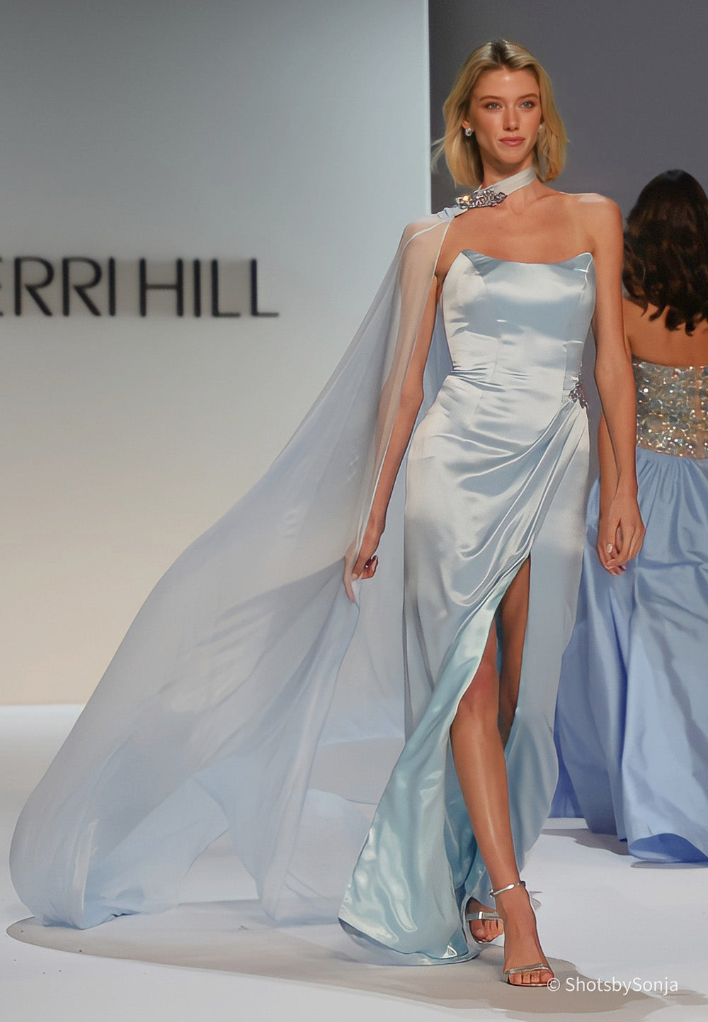 Sherri Hill 46757 light blue satin couture gown with flowing chiffon panel and stone embellishment at shoulder and hip
