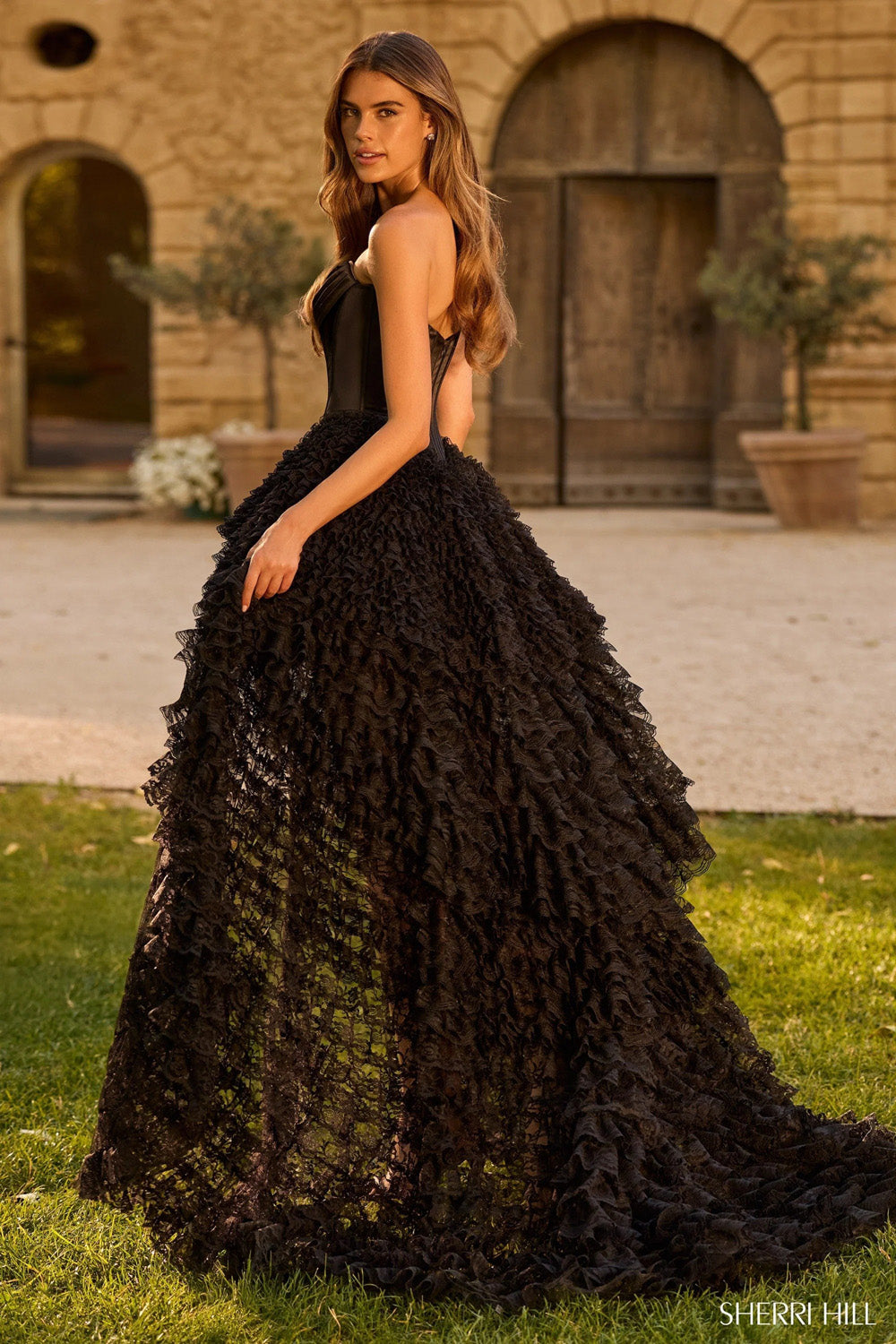 Sherri Hill 58577 black corset gown showing full tiered ruffle ball skirt and train from side