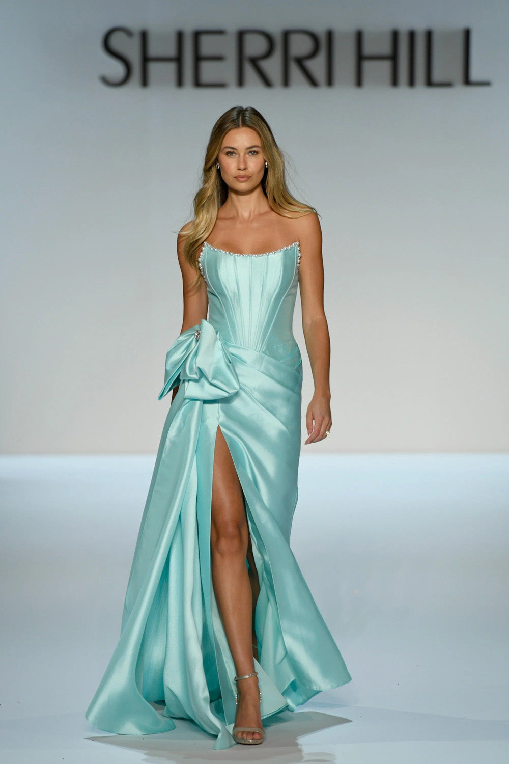 Sherri Hill 58676 aqua satin strapless gown with beaded scoop neckline oversized bow and A-line slit skirt full runway view