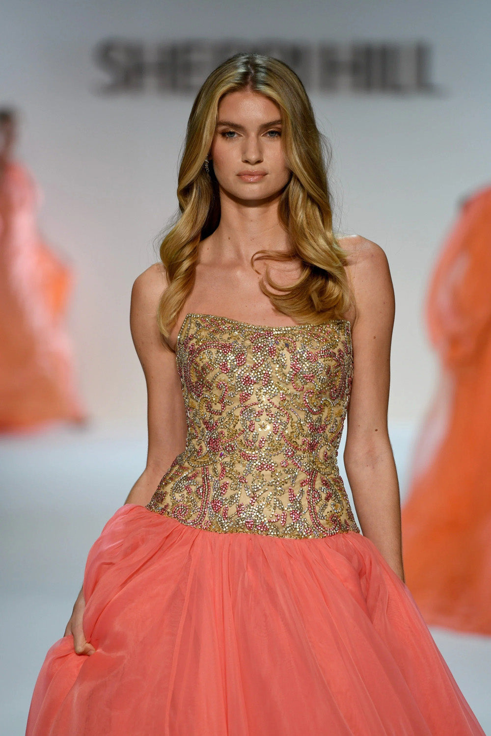 Sherri Hill 67344 close up of gold and pink beaded scrollwork bodice with coral tulle ballgown skirt