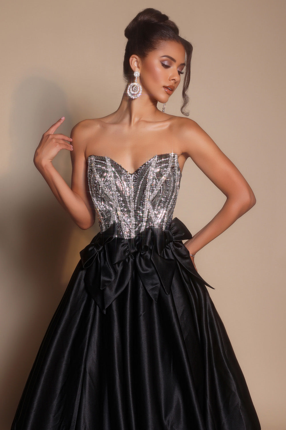 Portia and Scarlett PS26077 Black and silver prom dress with a fitted bodice and bow detail, front view.