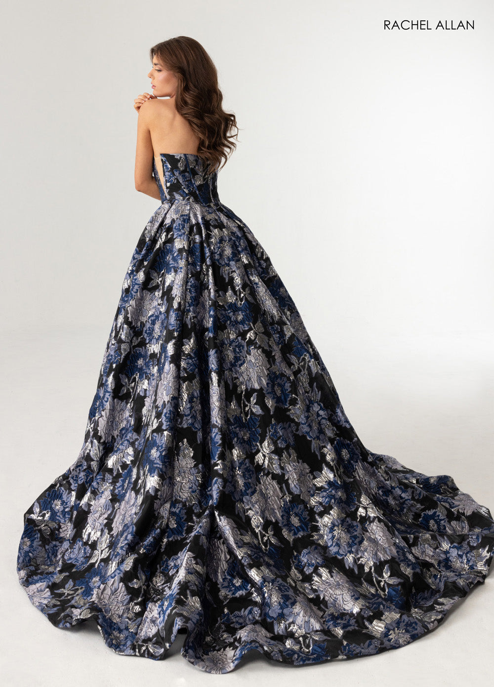 Rachel Allan 70975 Black multi formal gown with floral jacquard and a dramatic train, back view.