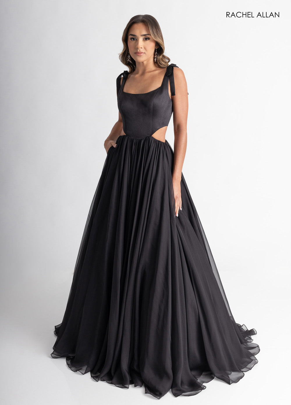 Rachel Allan 70980 Black A-line prom dress with cutouts and flowing chiffon skirt.