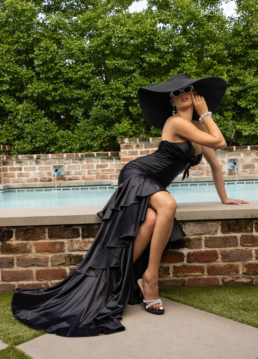 Rachel Allan 70987 Black mermaid prom dress with ruffled hem and thigh-high slit, front view.