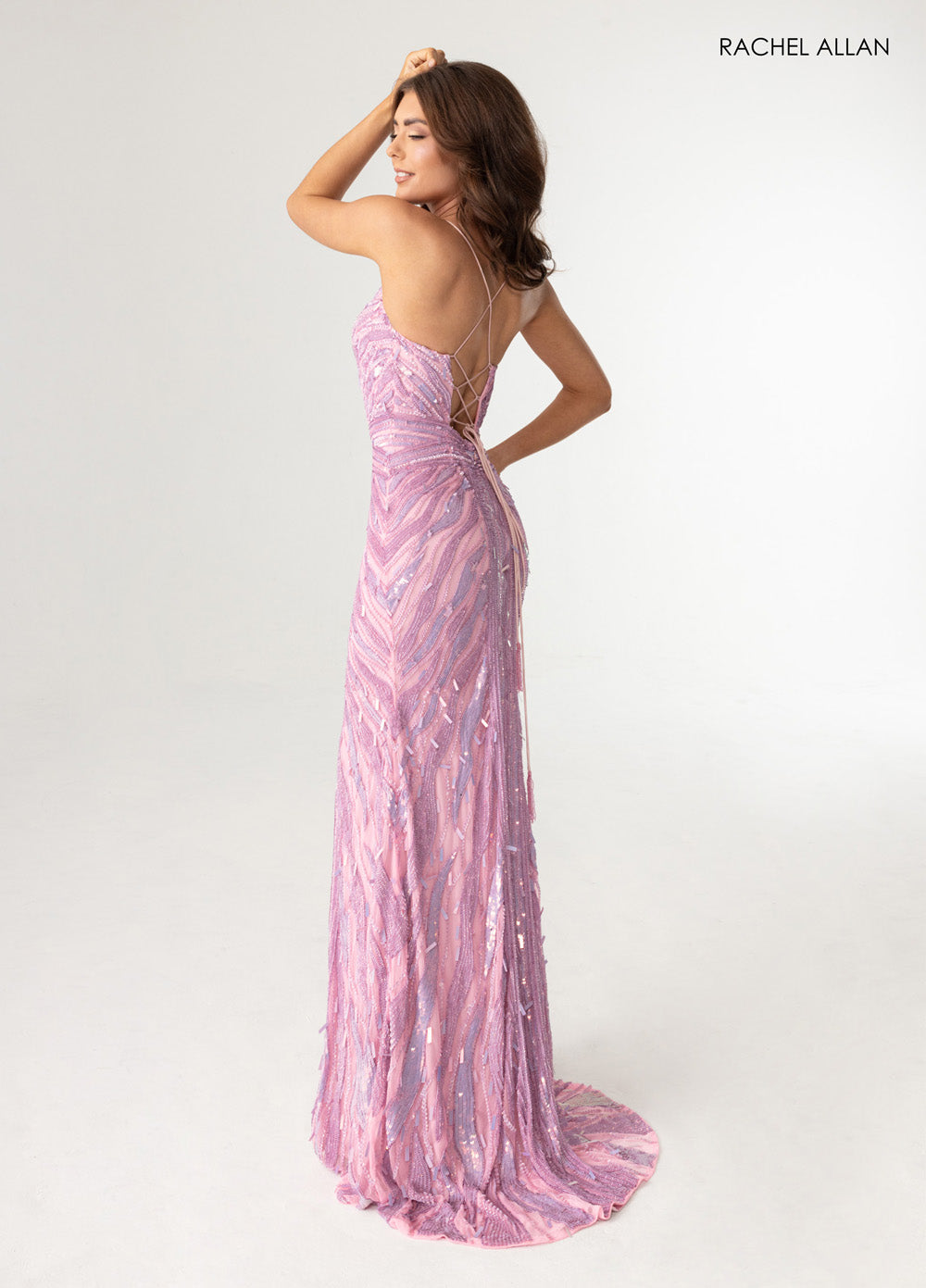Rachel Allan 70990 Pink formal gown with a lace-up back and shimmering beading, side view.