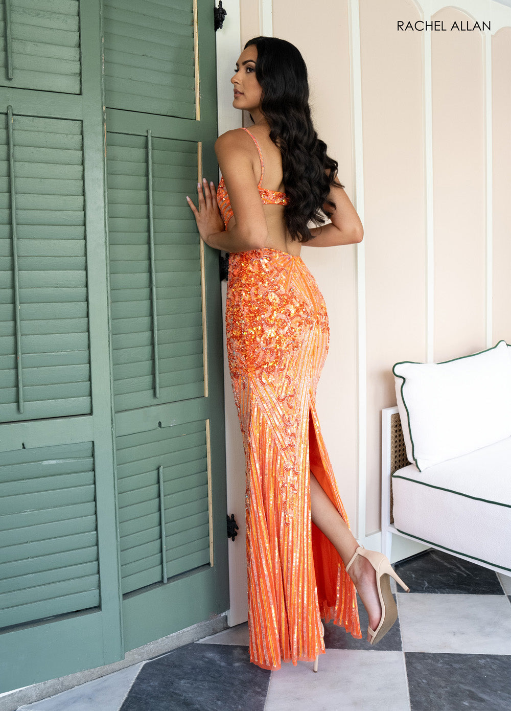 Rachel Allan 71007 Orange fitted prom dress with beading and a thigh-high slit, side view.