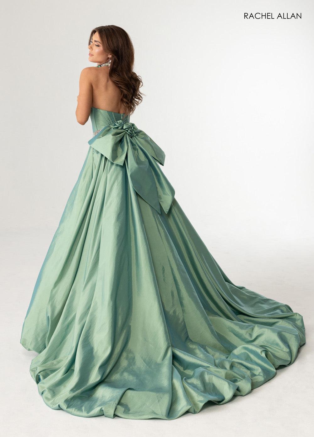 Rachel Allan 71024 Sage green ballgown with a dramatic bow and crystal beading, back view prom dress.