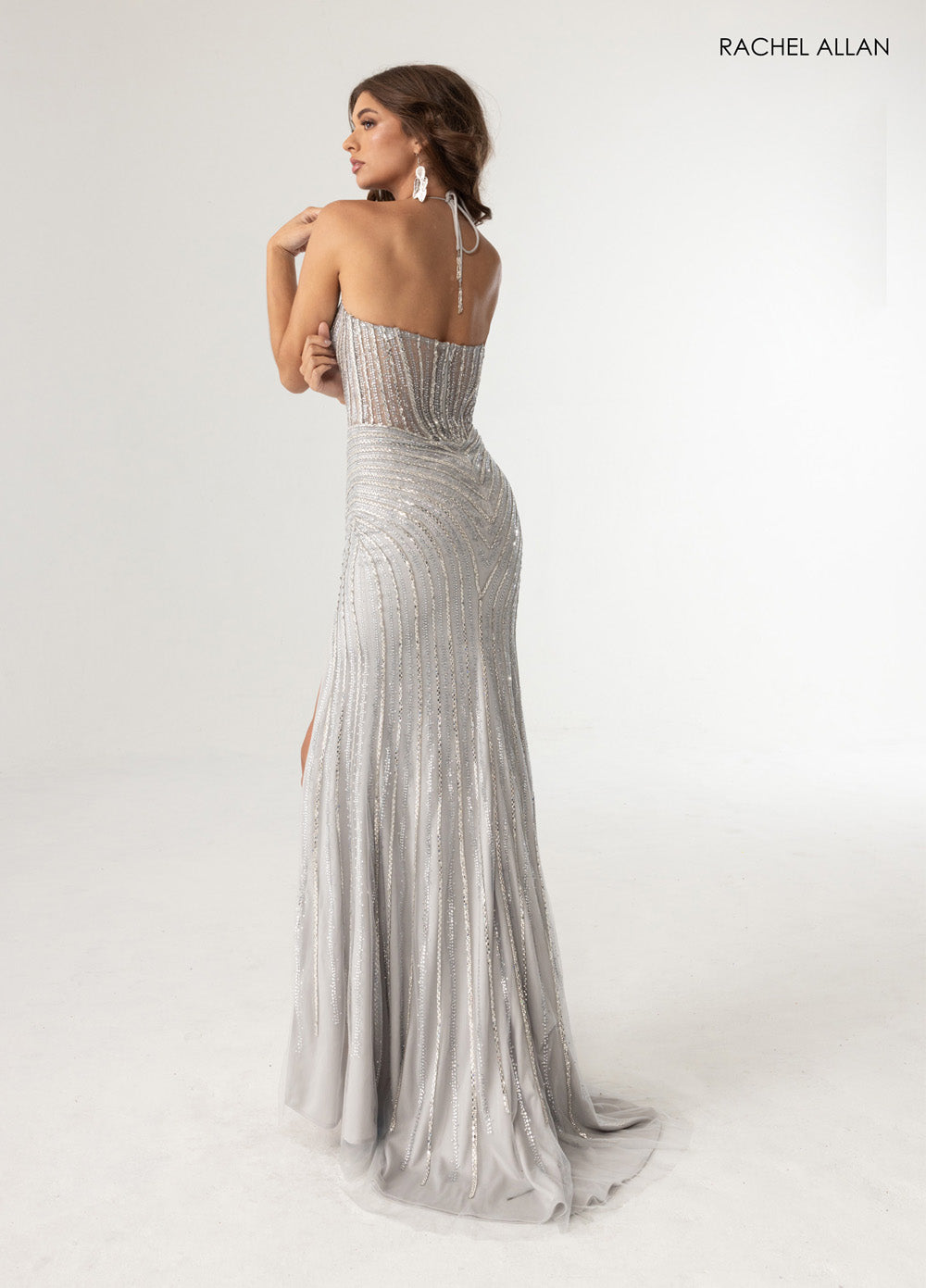 Rachel Allan 71025 Silver fitted prom dress with crystal beading and a side slit, back view.