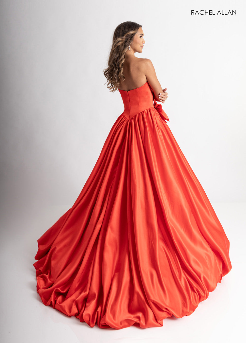 Rachel Allan 71035 Red ballgown with a flowing skirt and a bow detail at the back, perfect for prom prom dress.