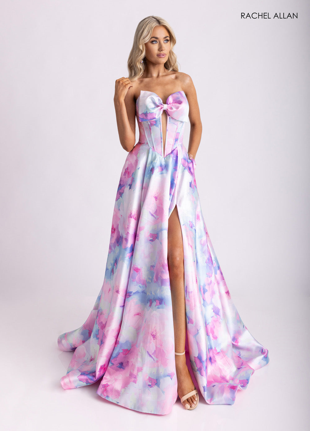 Rachel Allan 71036 Strapless pink multi prom dress with a high slit and bow detail.