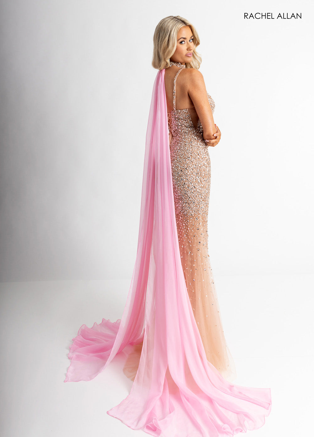 Rachel Allan 71047 Nude pink formal gown with crystal beading and a flowing cape, back view.