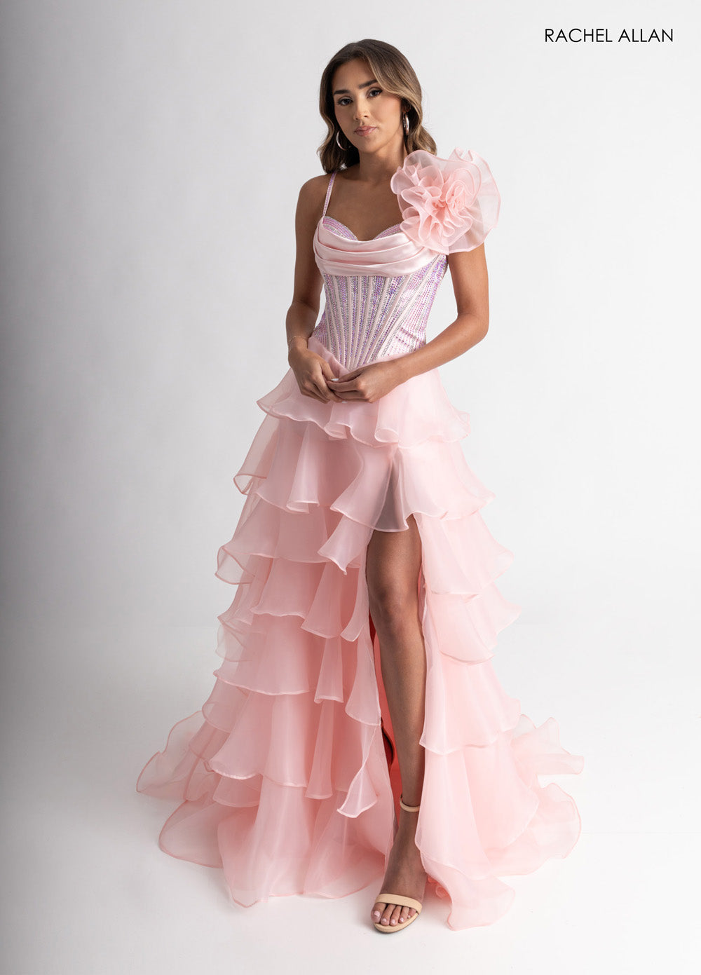 Rachel Allan 71049 Blush prom dress with layered ruffles and a dramatic side slit.