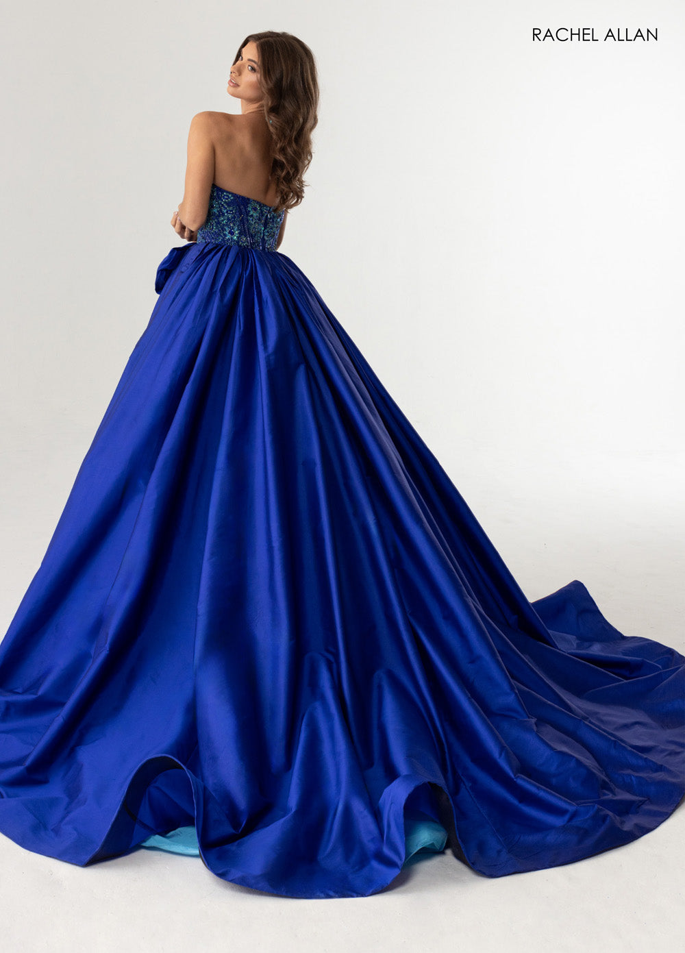 Rachel Allan 71068 Royal turquoise ballgown with beaded bodice and flowing train, back view prom dress.