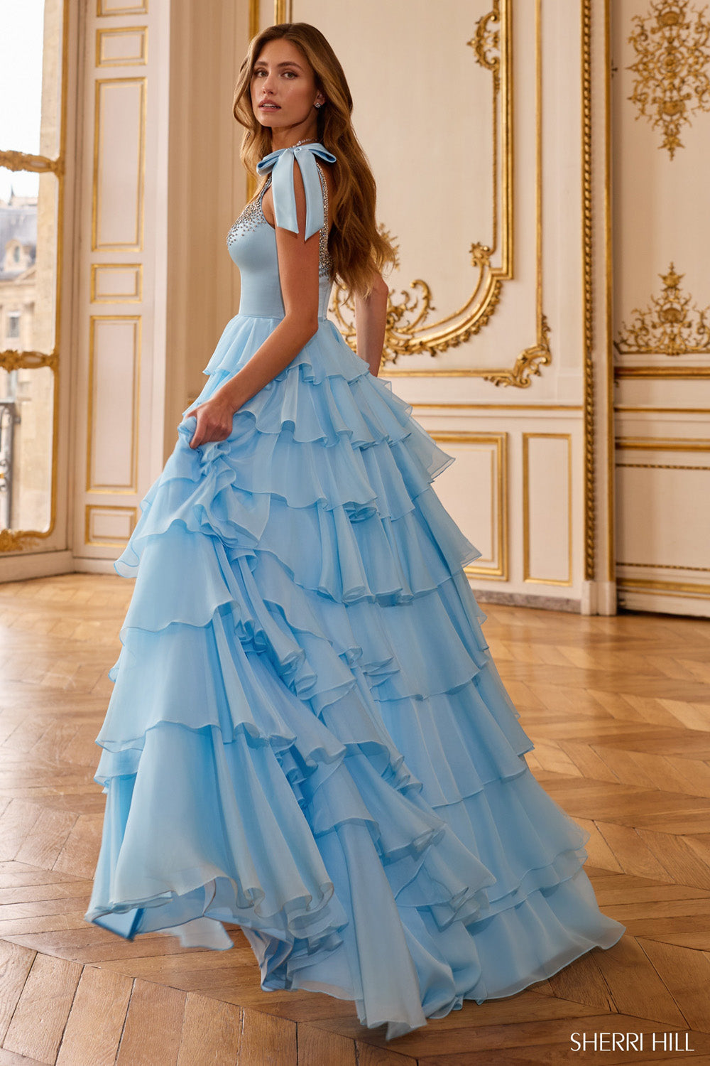 Sherri Hill 58041 light blue tiered ruffle ball gown side profile showing bow strap detail, beaded bodice, and sweeping organza skirt layers.
