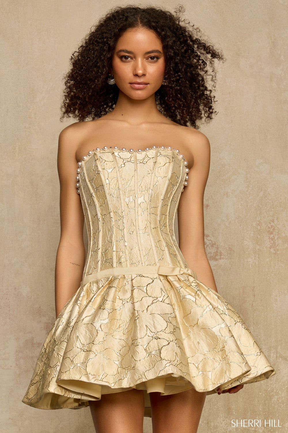 Front view of Sherri Hill 58362 gold print strapless corset homecoming dress with pearl-lined sweetheart neckline and full drop-waist skirt.