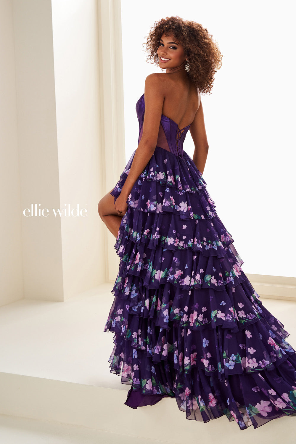 Ellie Wilde EW37001, A-line dark purple prom dress with floral layers and lace-up back.
