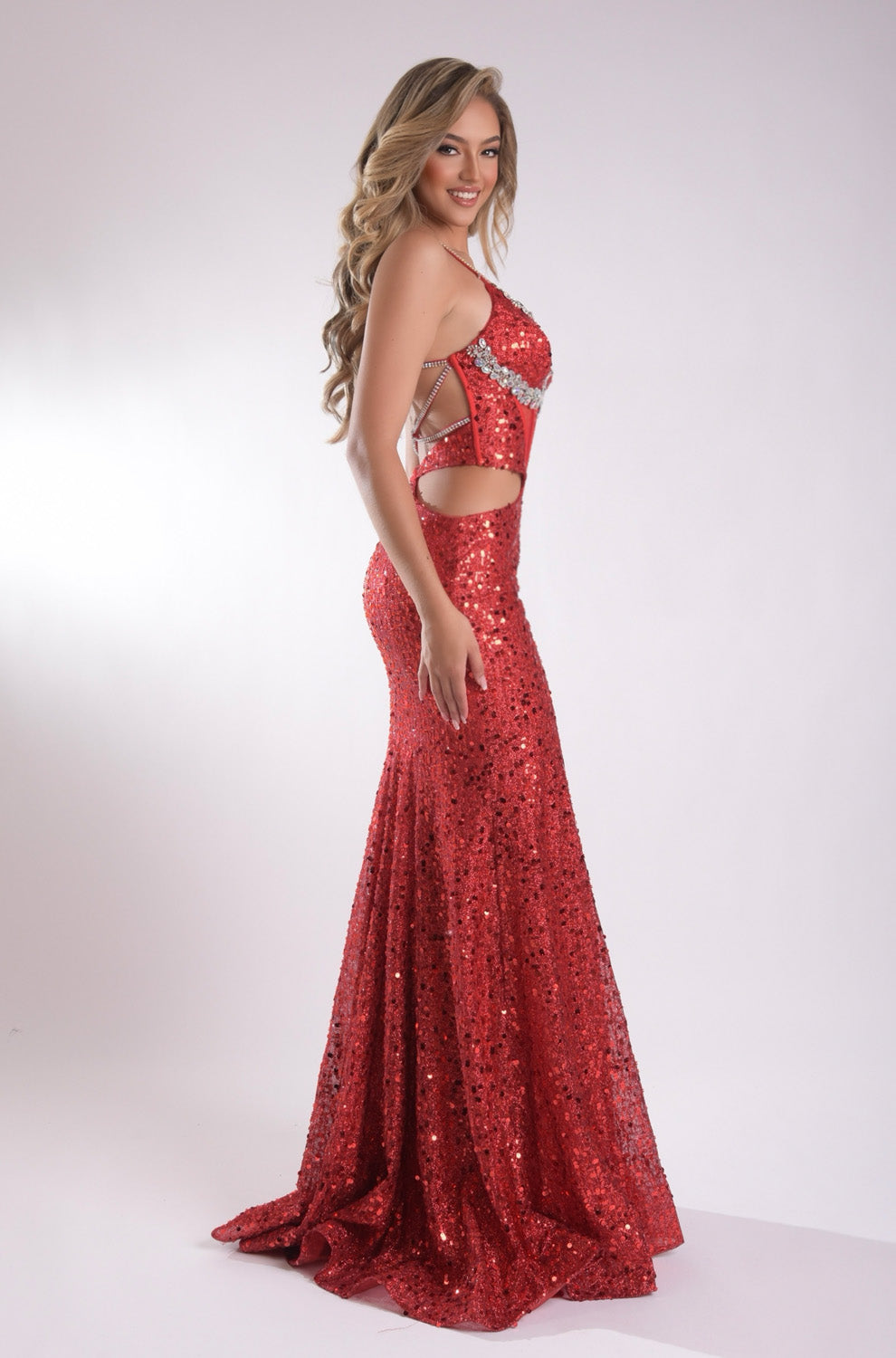 Jasz Couture 7916 Red mermaid prom dress with sequins and cut-out sides, side view.