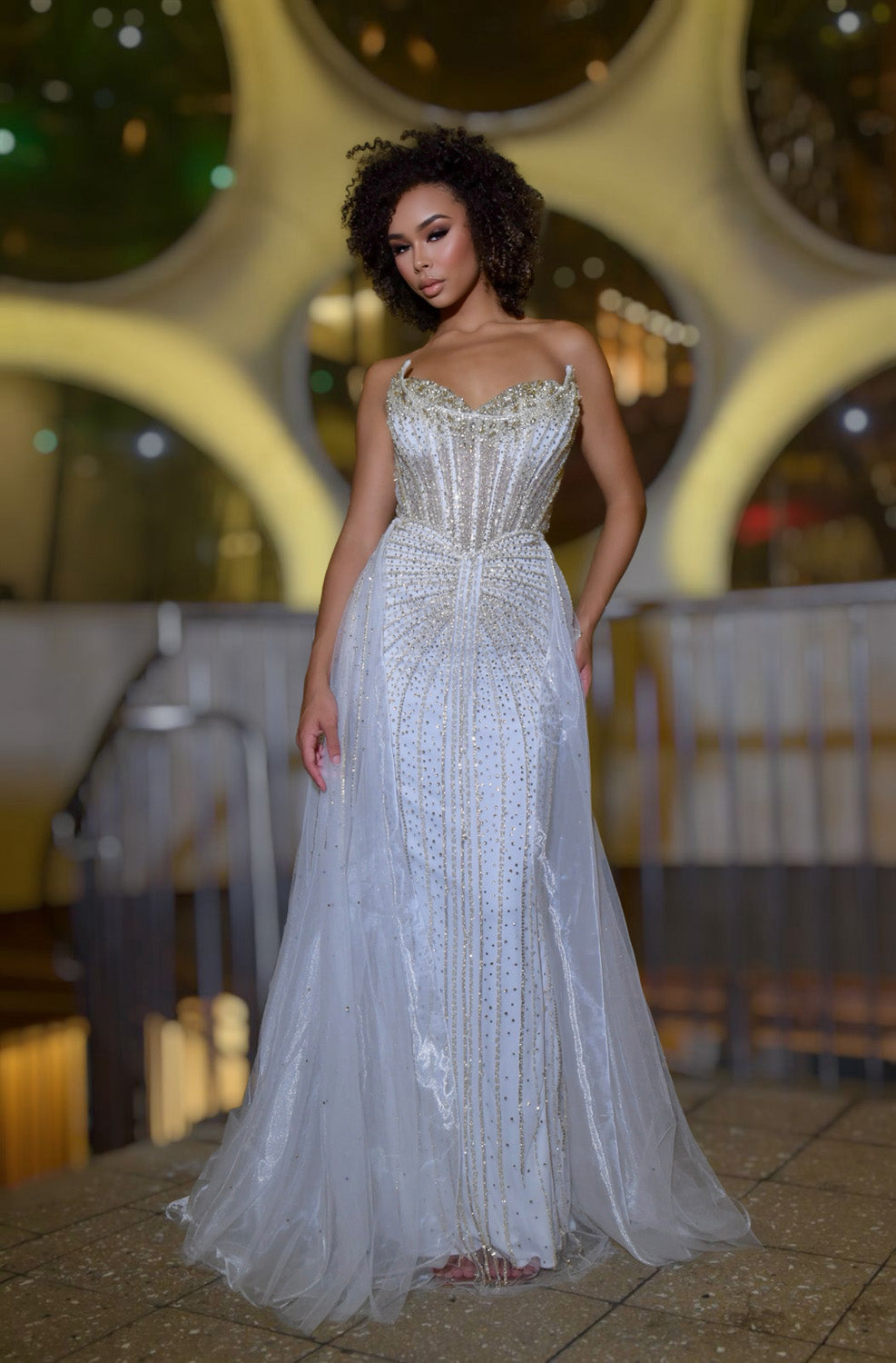 Jasz Couture 7932 White gold mermaid prom dress with beaded bodice and sheer overlay, front view.