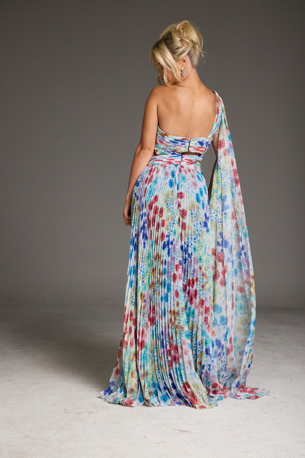 Jovani 38689 Colorful floral print A-line prom dress with a flowing cape and pleated skirt.