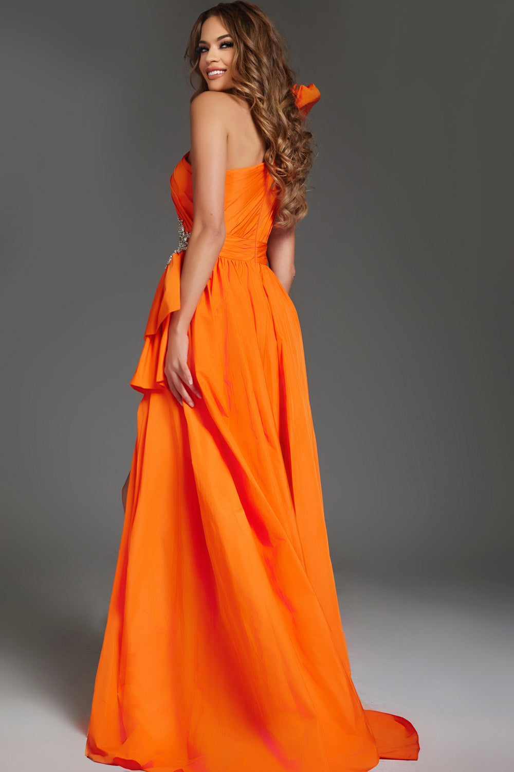 Jovani 40929 Orange formal gown with a fitted bodice and dramatic bow detail, back view.