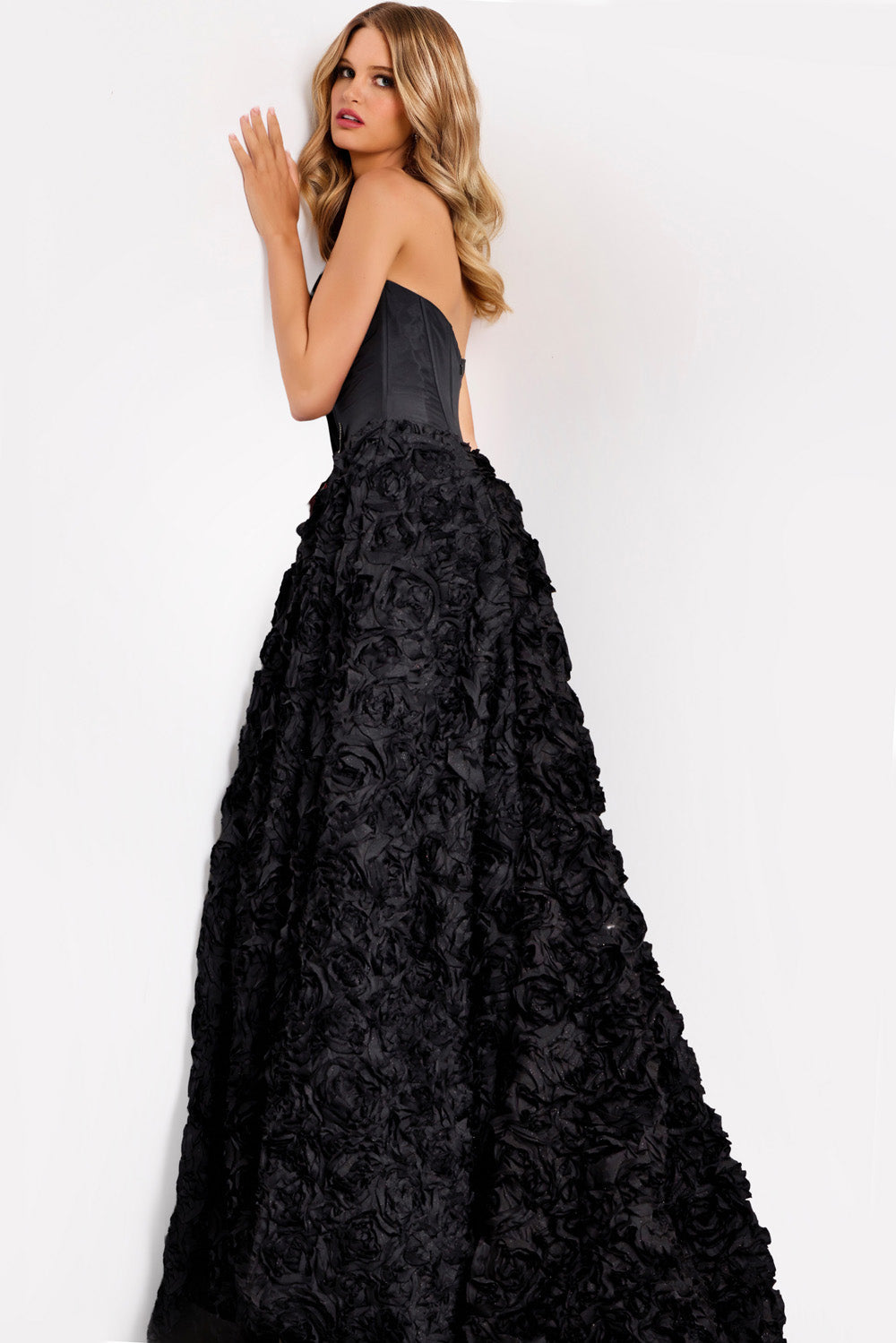 Jovani 47695 Black ballgown prom dress with floral texture and a corset back, side view.