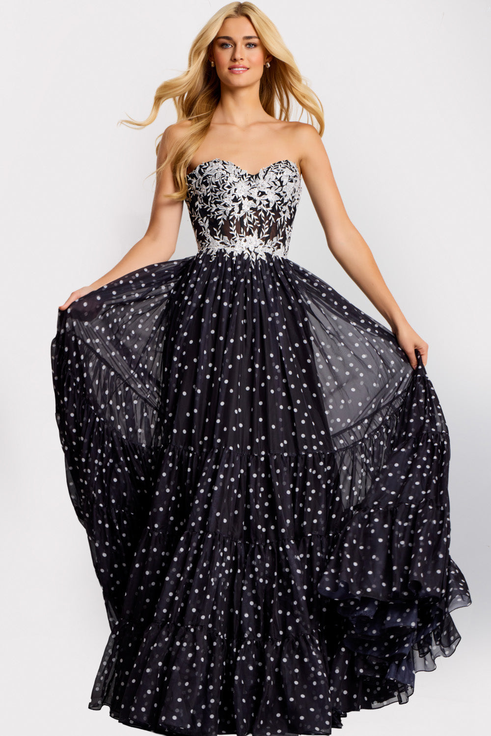 Jovani 49086 Black A-line prom dress with floral embroidery and a flowing polka dot skirt.