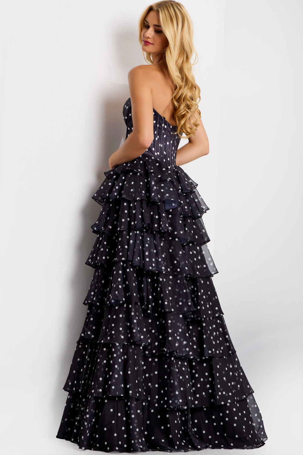 Jovani 49087 Black strapless prom dress with tiered ruffles and a corset back, back view.
