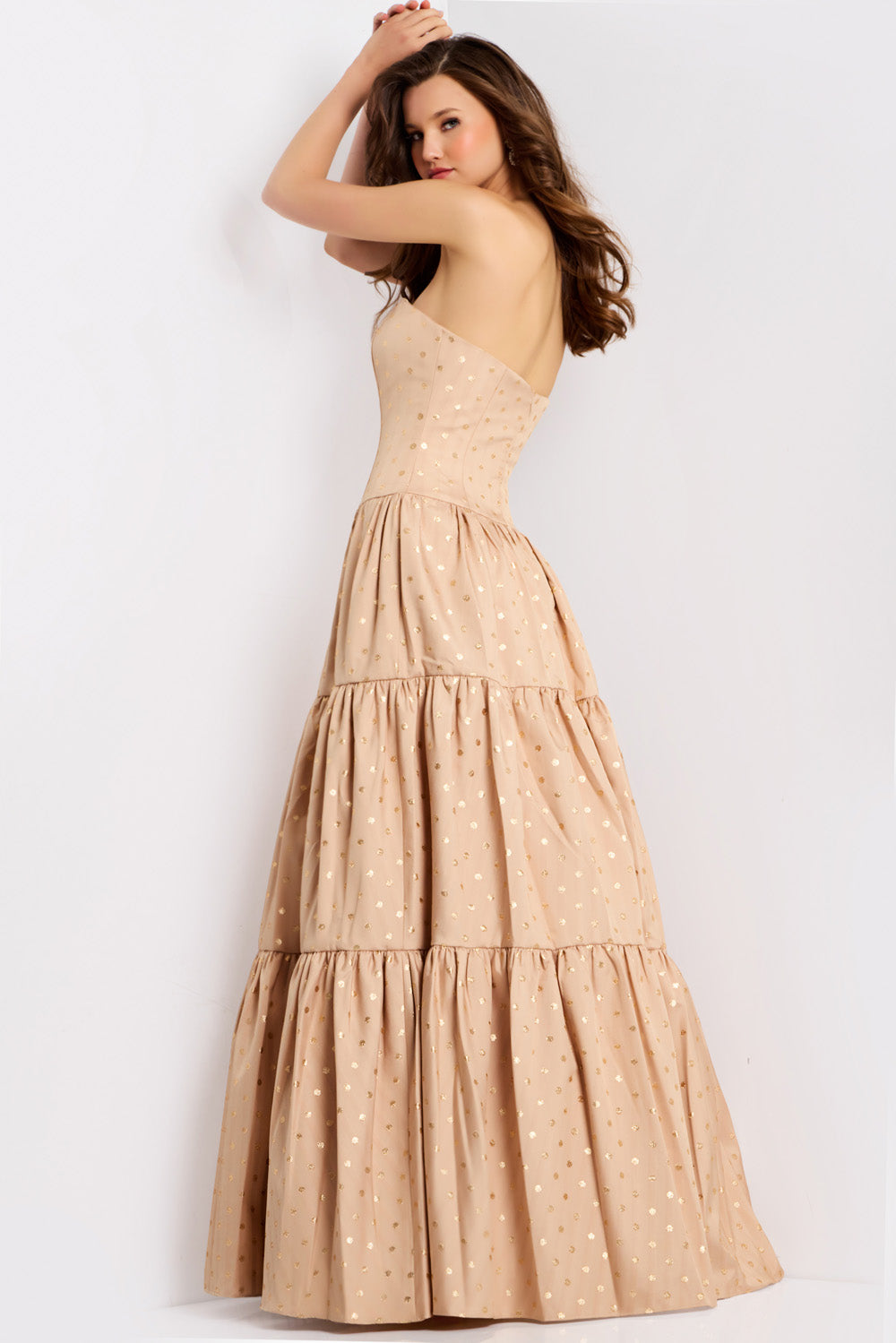 Jovani 49341 Strapless beige formal gown with gold polka dots and tiered skirt, back view.