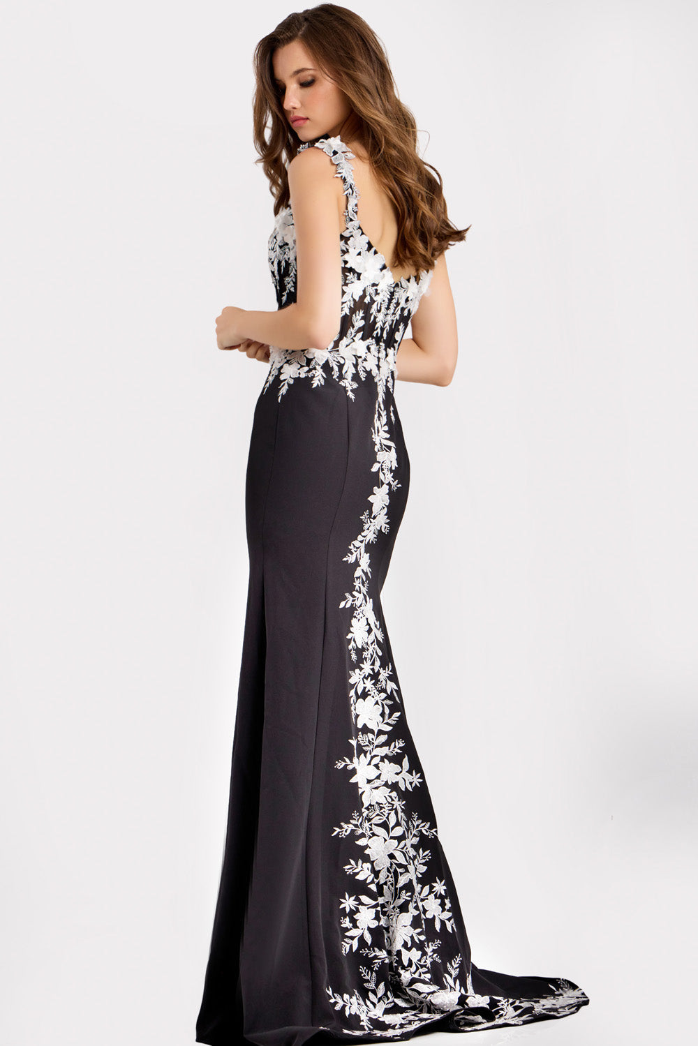 Jovani 49465 Black mermaid prom dress with floral embroidery and a side slit, back view.