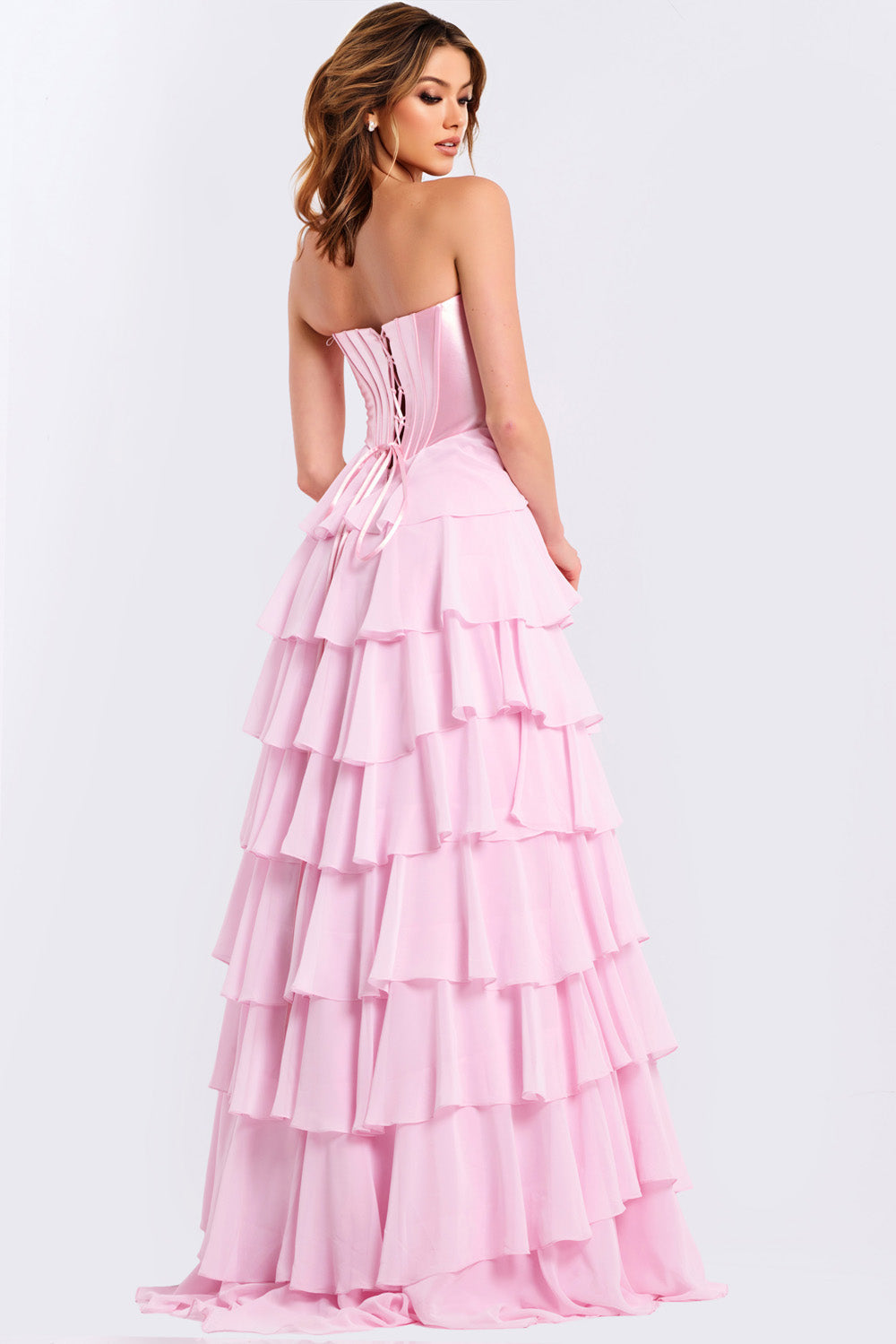 Jovani 50234 Pink tiered prom dress with a corset lace-up back, side view.