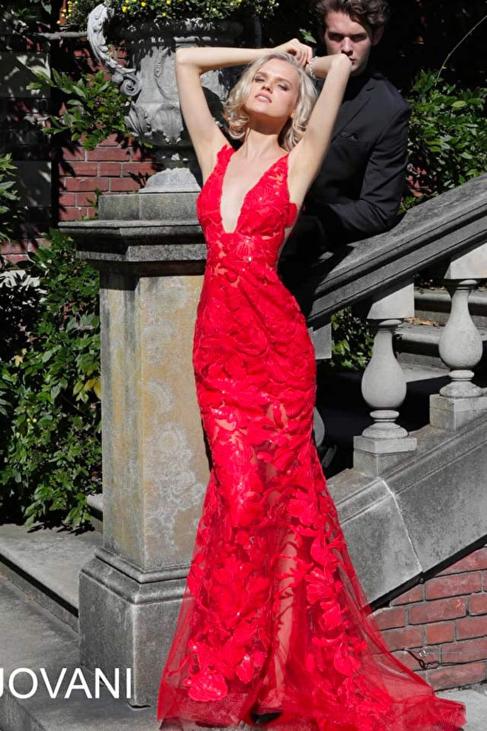 Jovani 60283 Red mermaid prom dress with floral lace and a plunging neckline, front view.